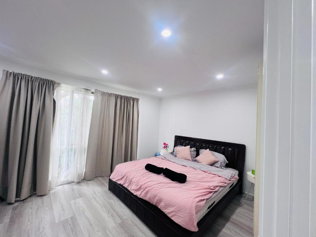 a bedroom with a large bed with pink sheets at Beautiful Room 1 Available in Berwick