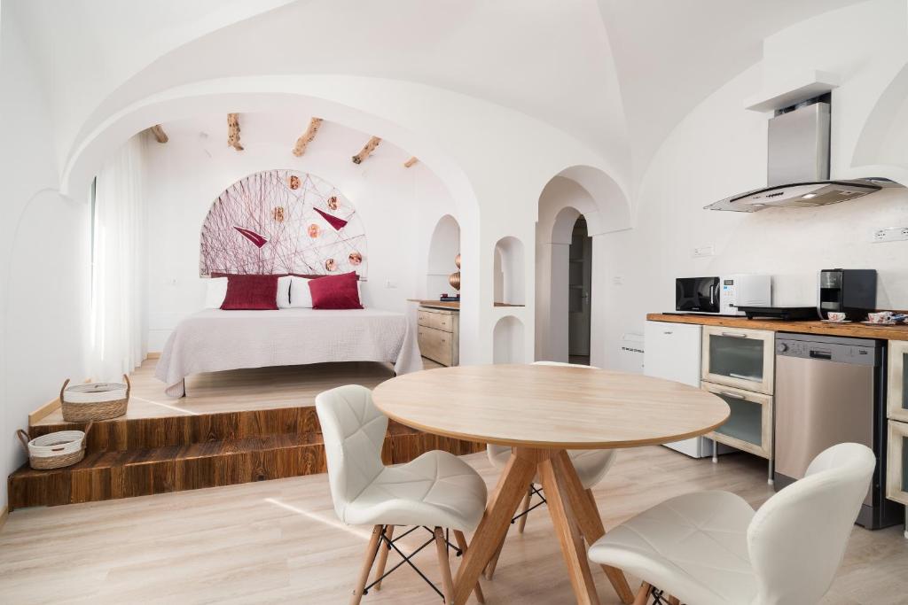 a kitchen and a bedroom with a table and chairs at Giojas125- Monolocale per 2 persone in Orosei