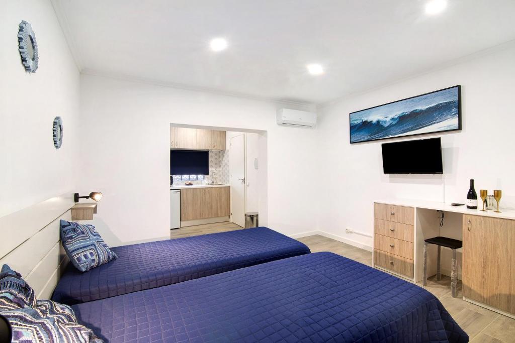 a bedroom with two beds and a desk and a tv at Apartamento nº4 - Beach in Moncarapacho