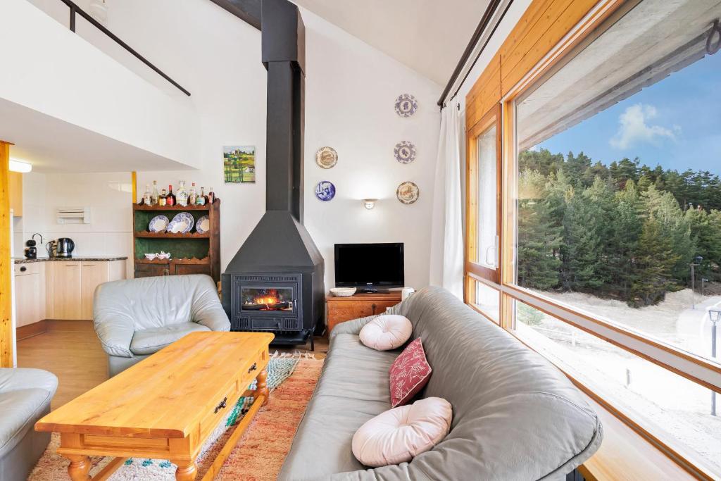 a living room with a couch and a fireplace at Masella in La Masella