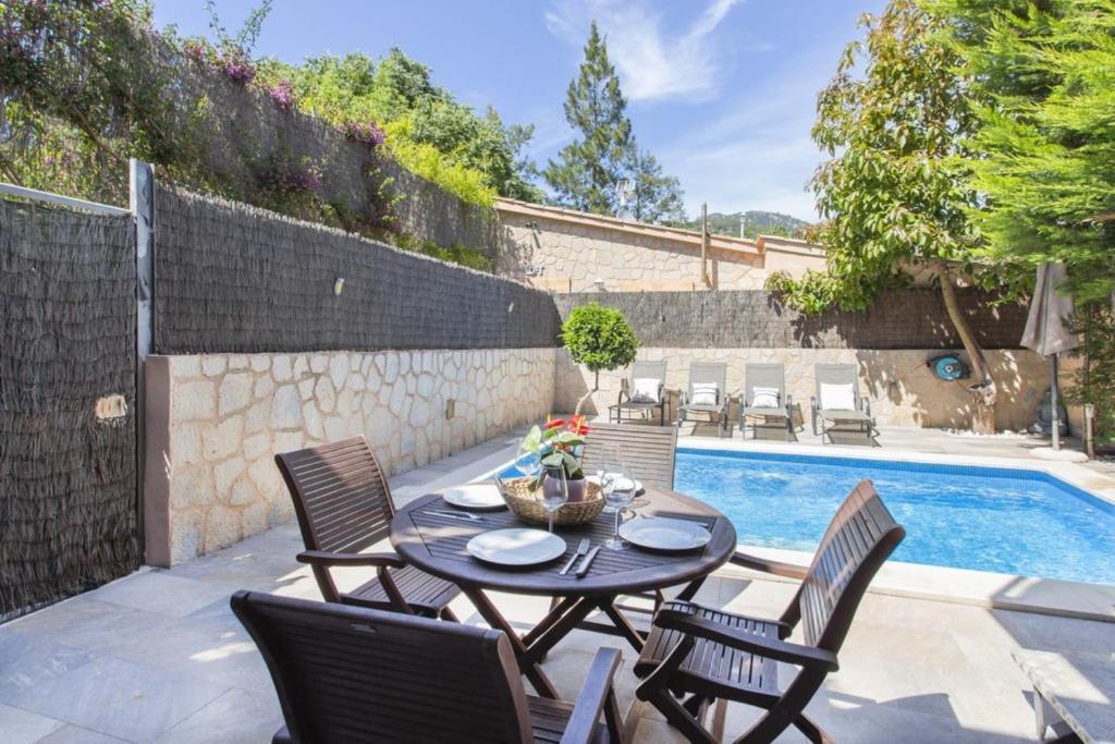 a patio with a table and chairs next to a swimming pool at Can Darder in Sóller