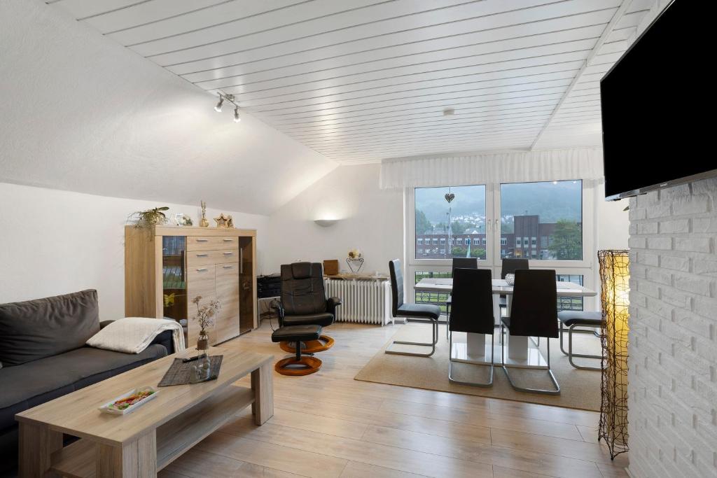 a living room with a couch and a table and chairs at Sara´s Ferienwohnung in Plettenberg