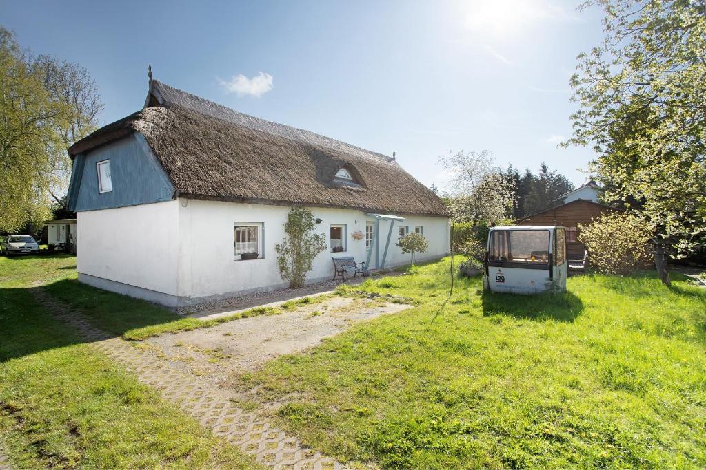 a white house with a thatched roof in a yard at Ferienhaus Struve in Trent