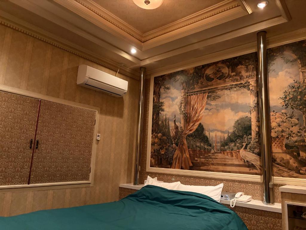 a bedroom with a painting on the wall and a bed at 福井ホテルシルビア in Fukui