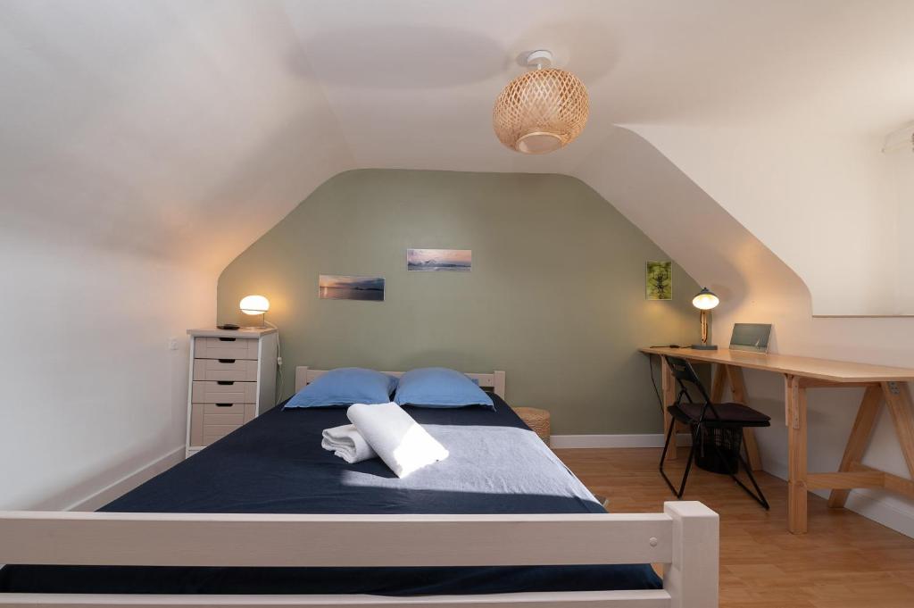 a bedroom with a bed and a desk at L'idéal, wifi, proche mer et Vannes in Noyalo