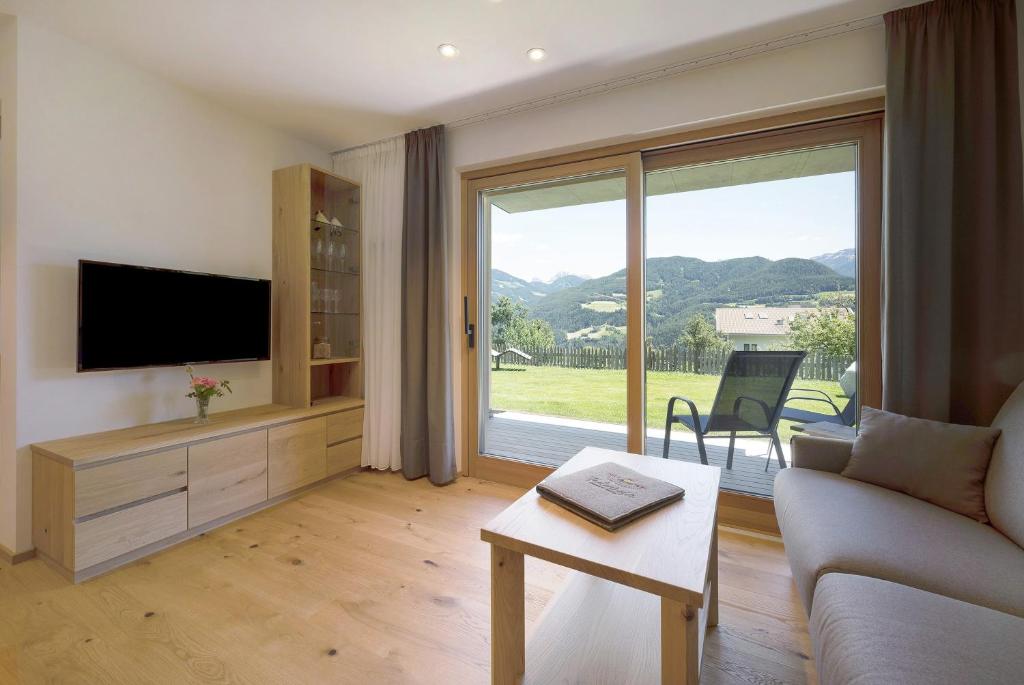 a living room with a couch and a television at Teutenhofer Kastanie in Feldthurns