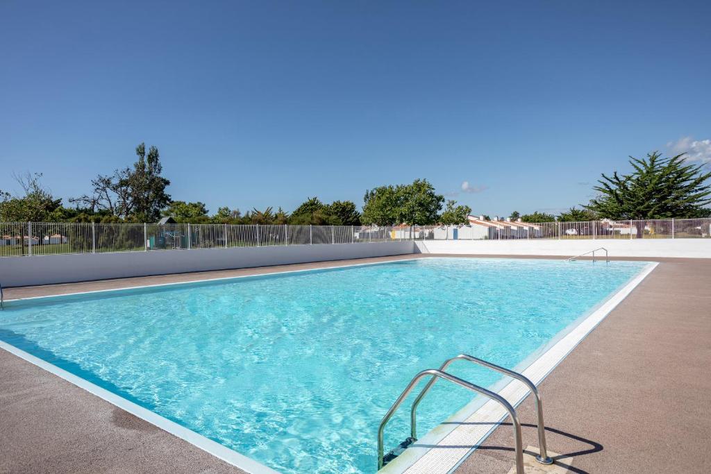a large swimming pool with blue water at Studio piscine partagée in Bretignolles-sur-Mer