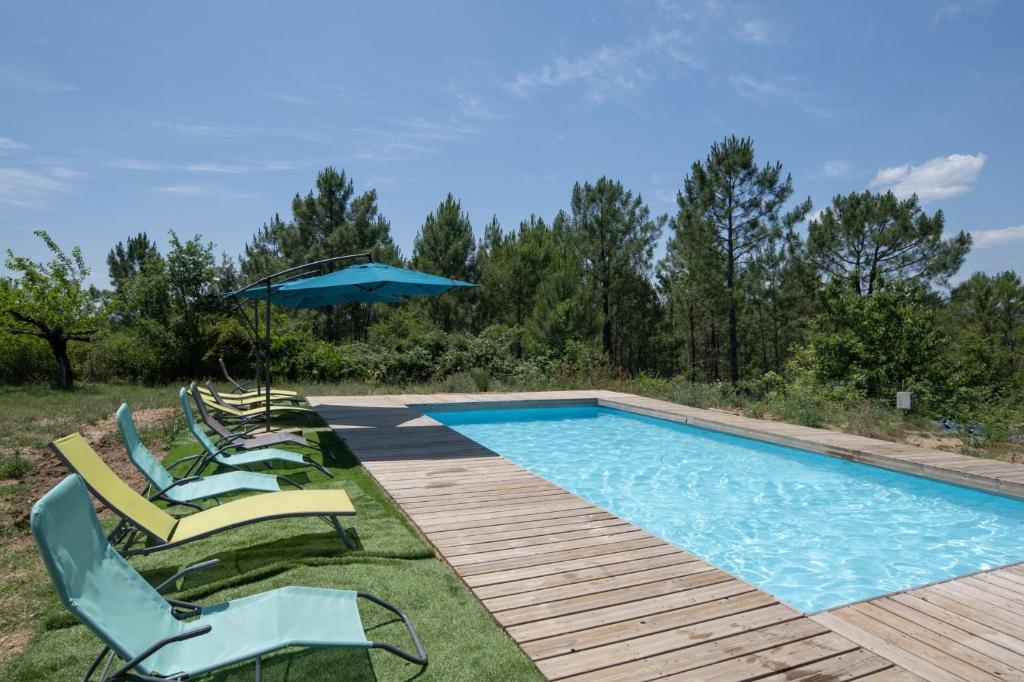 una piscina con lettini e un ombrellone di Hamlet a Lablachère