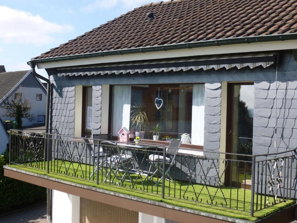a balcony of a house with a table and chairs at Ferienhaus Höhenflug in Attendorn