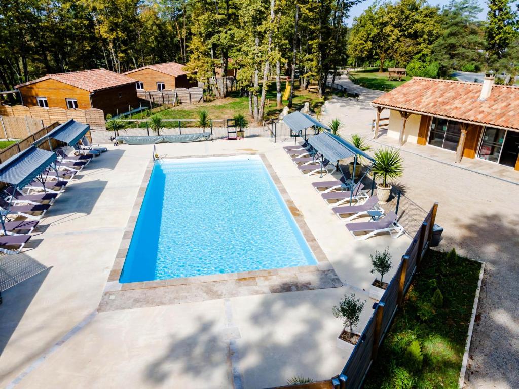 an overhead view of a swimming pool with chairs and a house at Gite 4 de l'Orée du Bois in Thenon