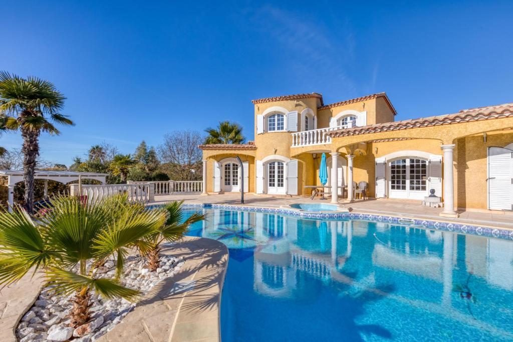 a large swimming pool in front of a house at Madrague St Vincent Apt B in Le Grau-dʼAgde