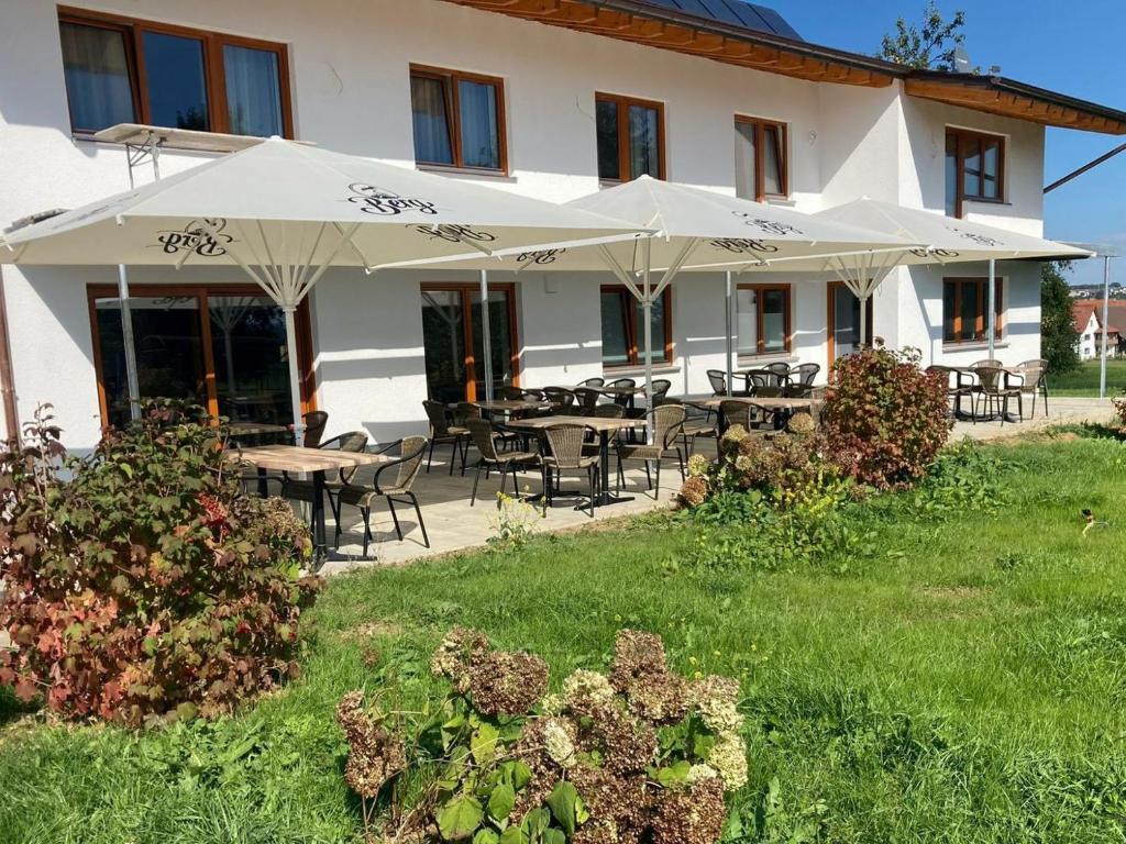 a building with tables and chairs and umbrellas at Casa Rural in Nerenstetten