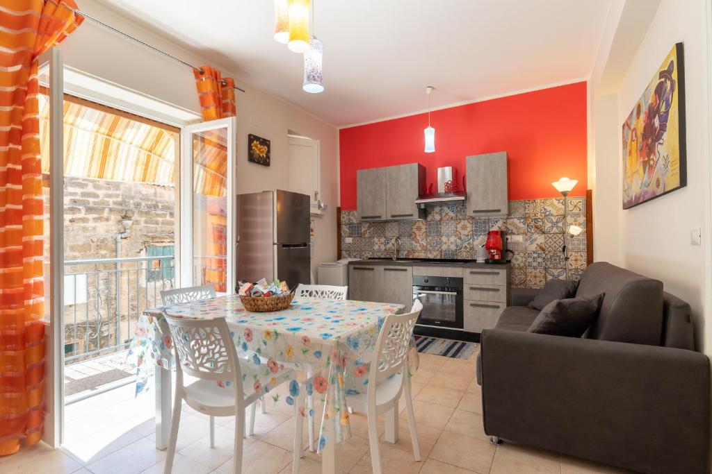 a kitchen and living room with a table and chairs at Leondoro - Pirandello in Santa Flavia