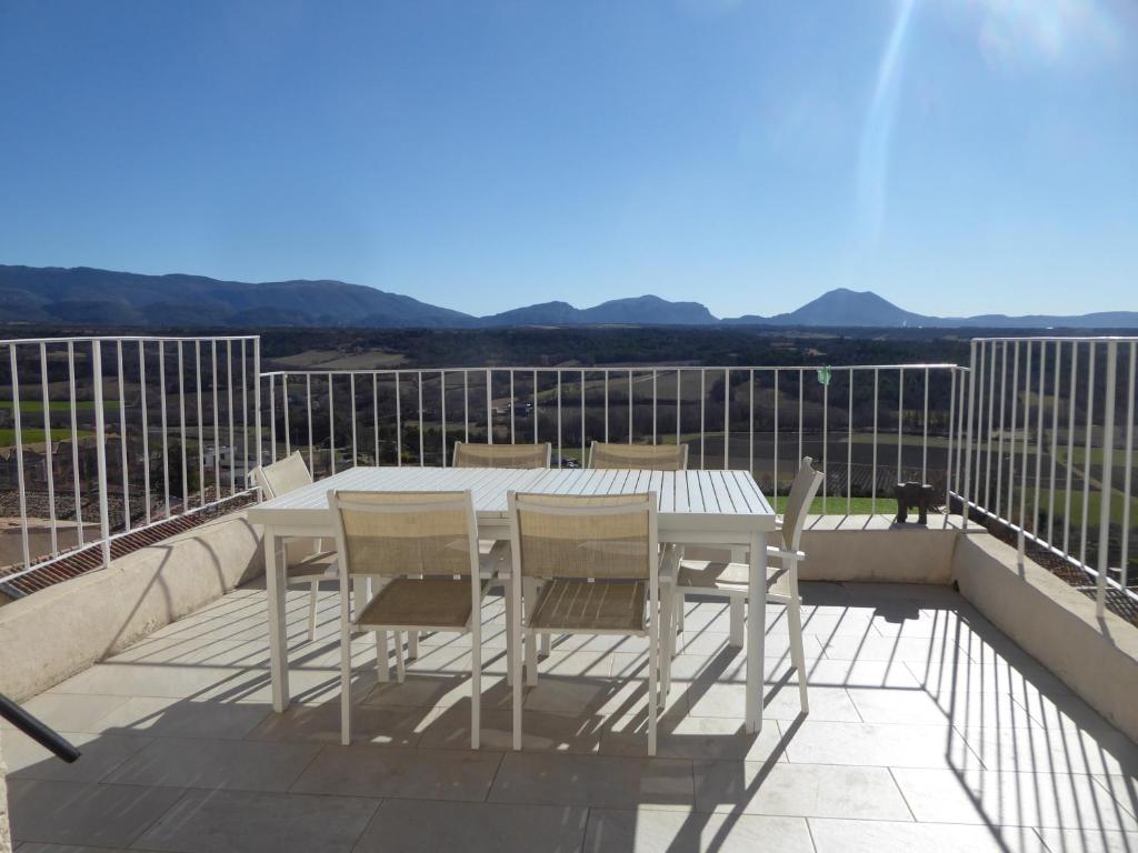 a white table and chairs on a balcony at Maison de Village in Puimoisson