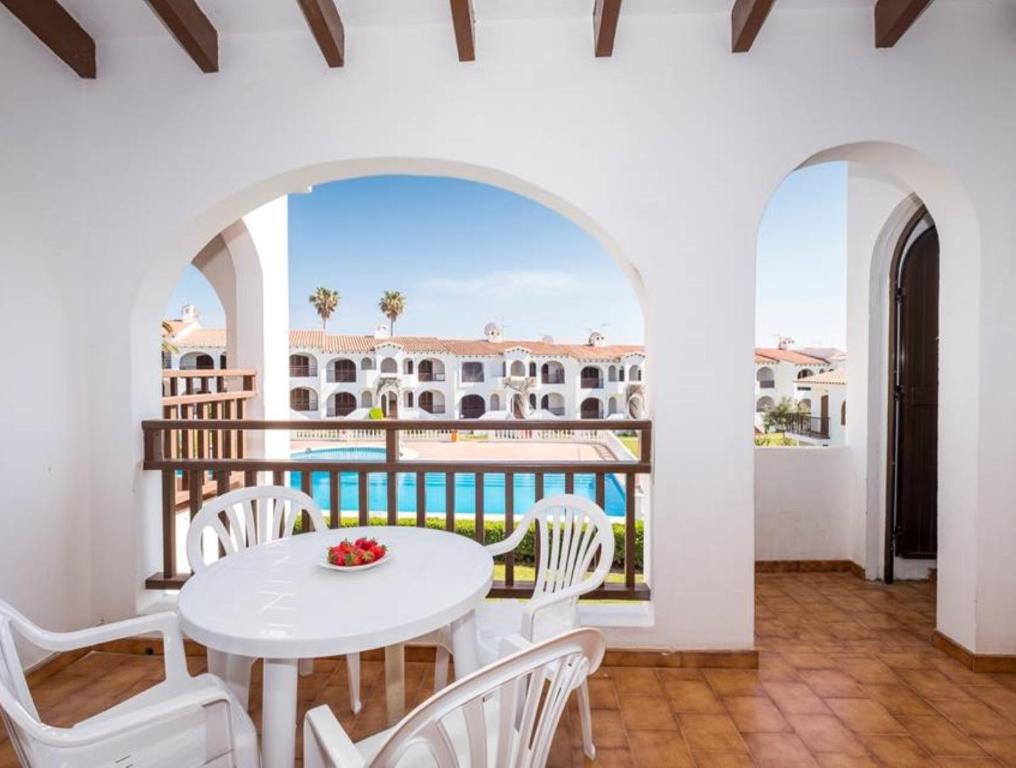 a balcony with a table and chairs and a view of the ocean at Girasol Garden Superior 2-a in Menorca