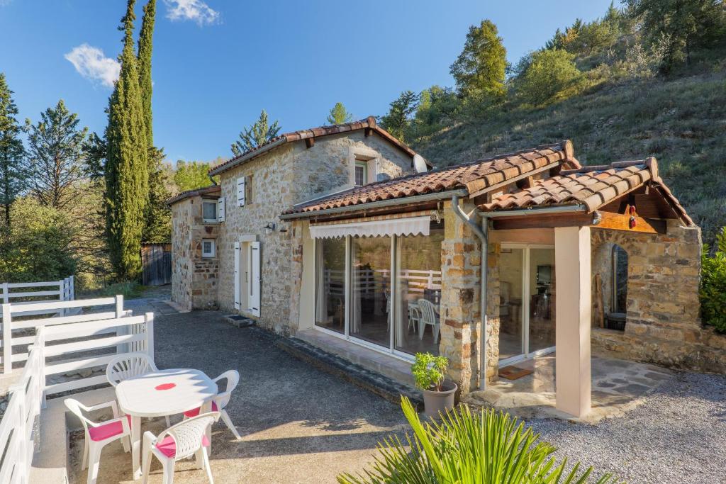 a small stone house with a table and chairs at Gite de la Troulière in Banne