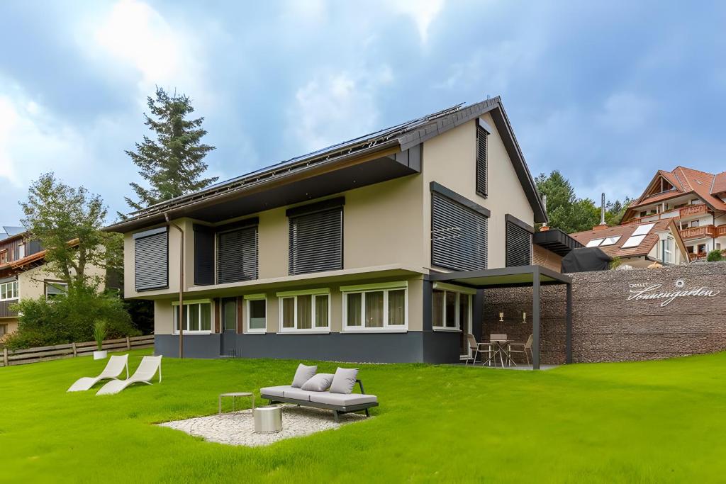 a house with a green lawn in front of it at Chalet-Sonnengarten in Hinterzarten