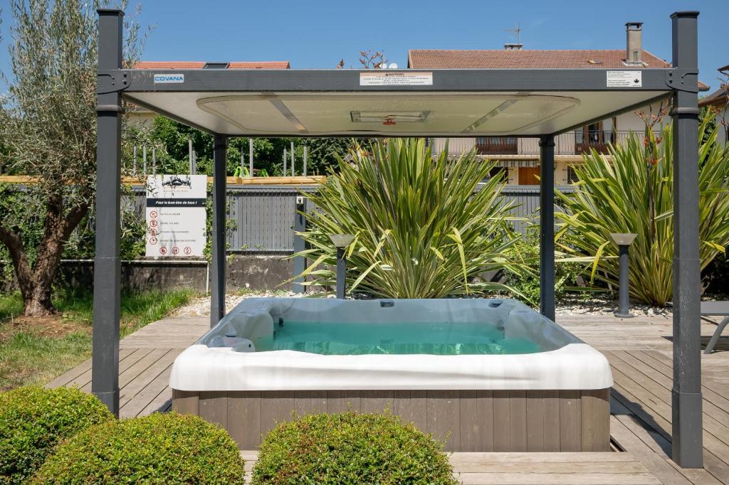 a hot tub in a gazebo in a garden at La suite des Sommets in Barberaz
