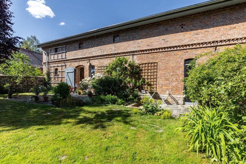 a brick building with a yard in front of it at Ferienwohnung im Pferdestall in Angermünde