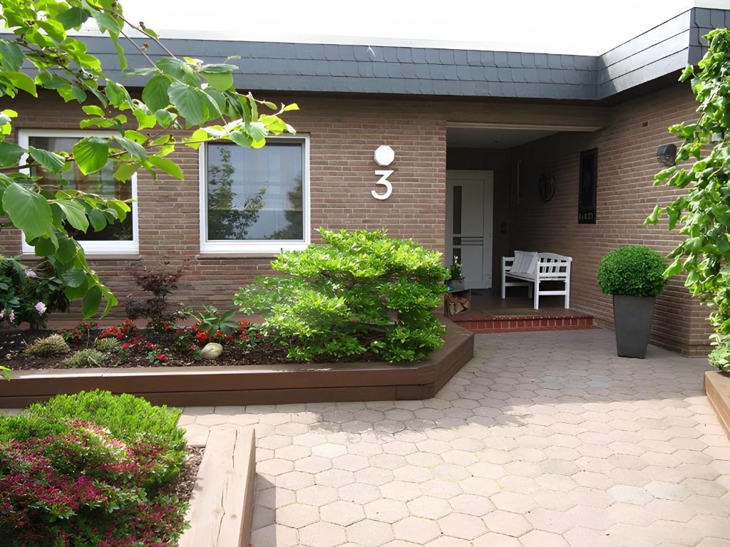 a brick house with a porch with a patio at Ferienwohnung Lortz in Cuxhaven