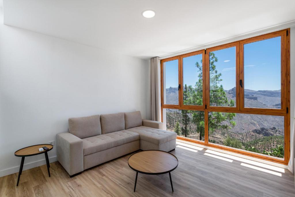 a living room with a couch and a large window at Los Mojones in Artenara
