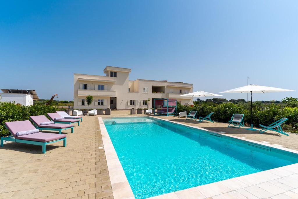 a villa with a swimming pool in front of a house at Le scuderie 5 in Galatone