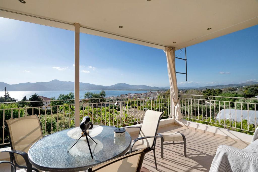 a patio with a glass table and chairs on a balcony at Villa Ermina Paleros in Paleros