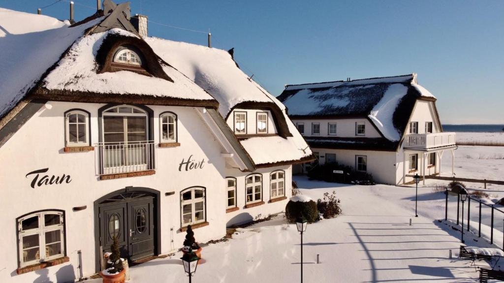 a white house with snow on the roof at Taun Hövt in Groß Zicker