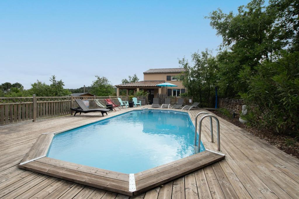 a swimming pool on a wooden deck at Villa La Fenière in Payzac