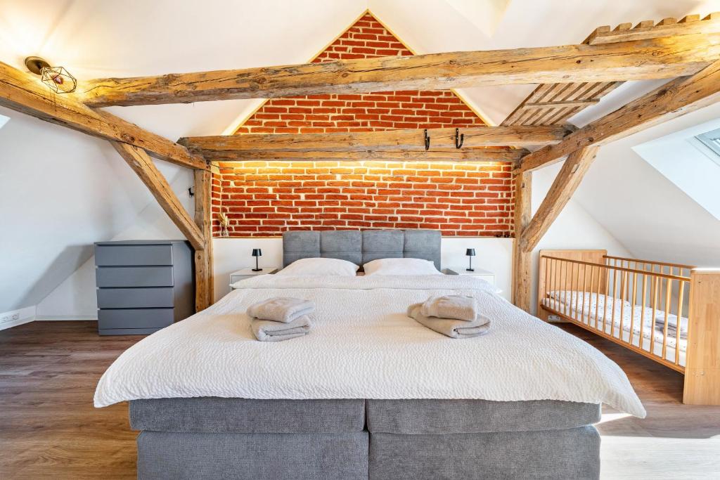 a bedroom with a large bed with a brick wall at Ferienhaus1856de mit Sauna in Görlitz