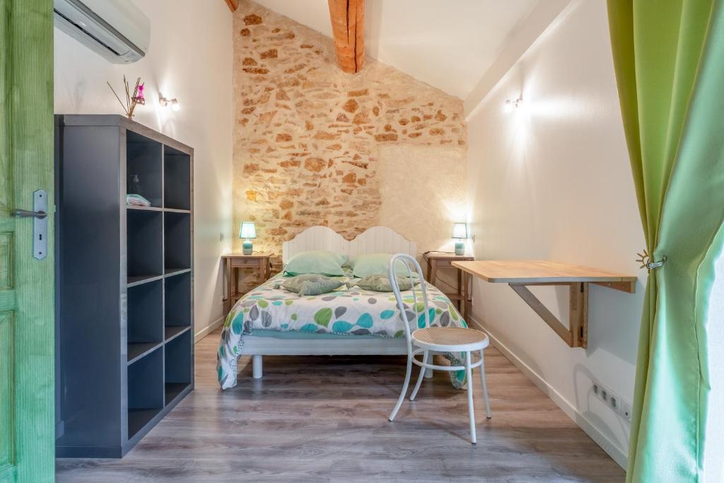 a small bedroom with a bed and a desk at Chambre Olive Verte in Piolenc