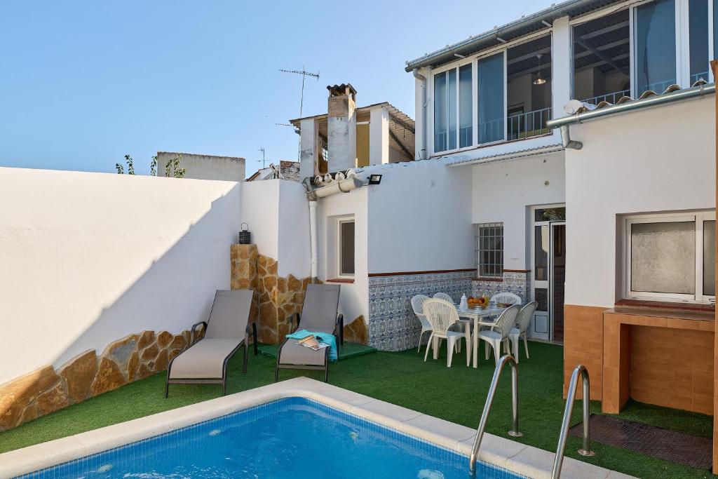 a patio with a swimming pool and a table and chairs at Casa Ángeles in Cuevas Bajas