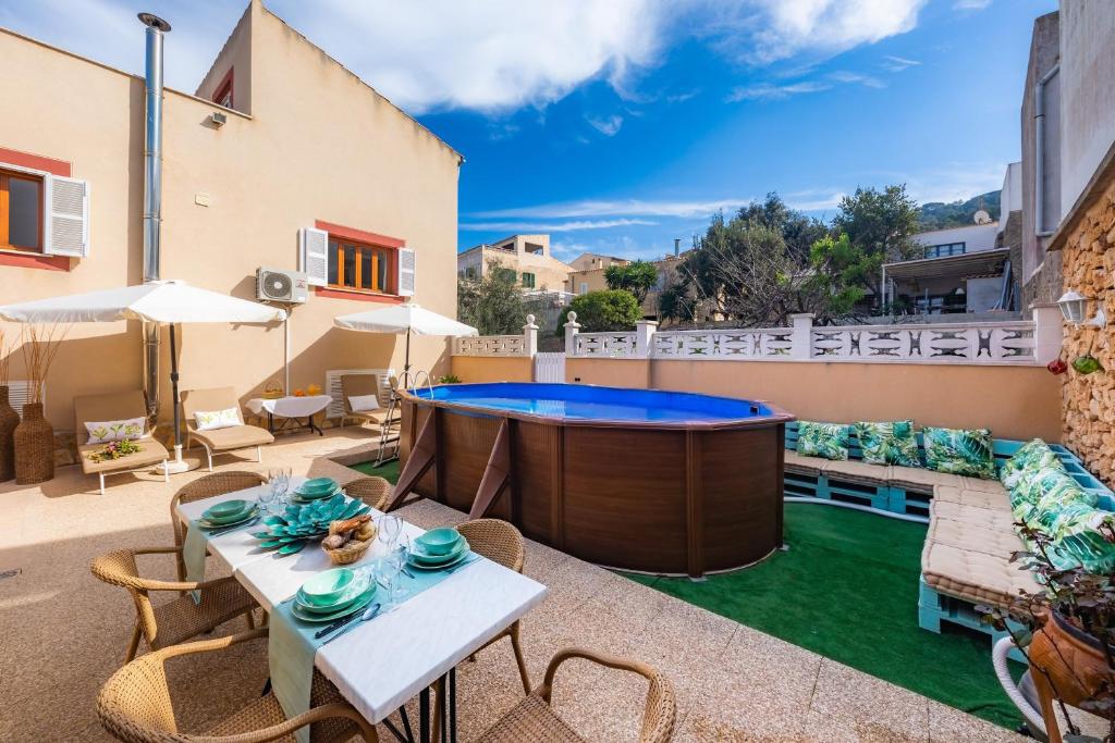 a patio with a pool and tables and chairs at Casa Hermosa in Capdepera