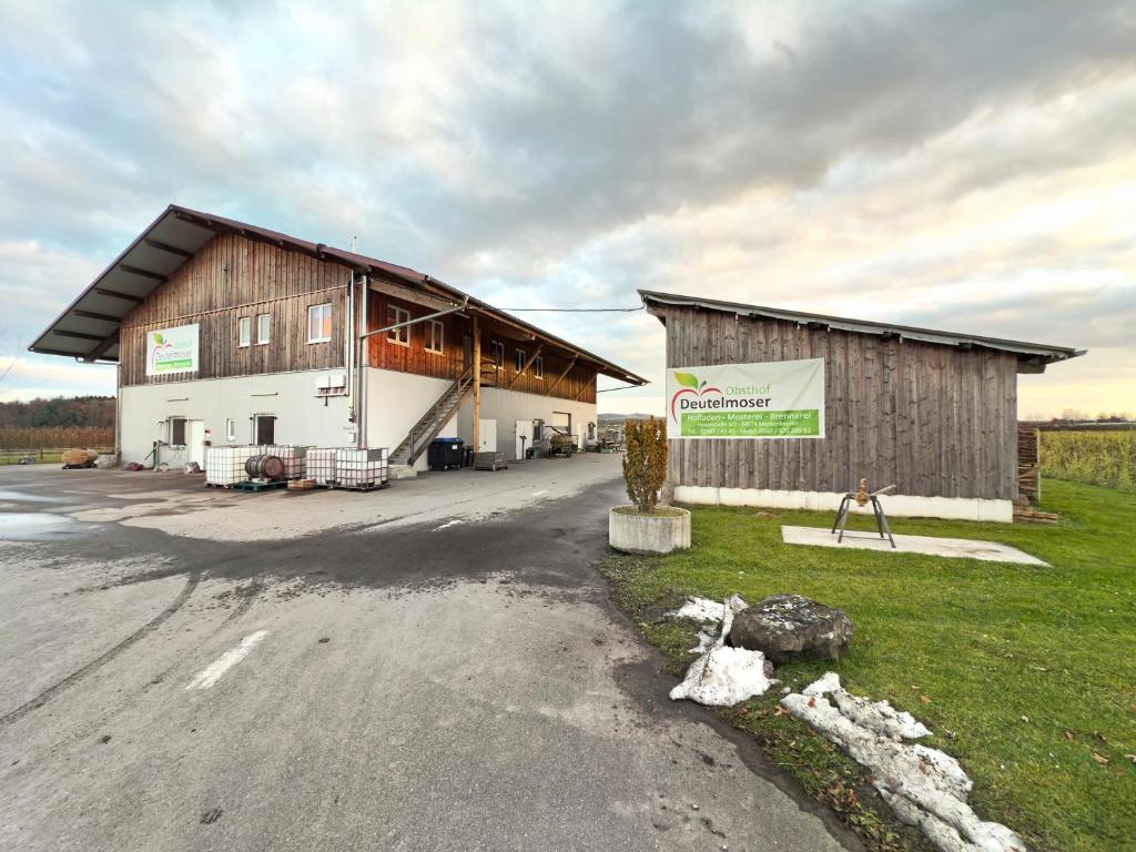 a large barn with a sign in front of it at Wohnung beim Obsthof in Meckenbeuren