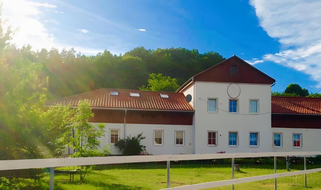 a large white building with a red roof at Herrenhaus Gut Buchenhof in Römhild