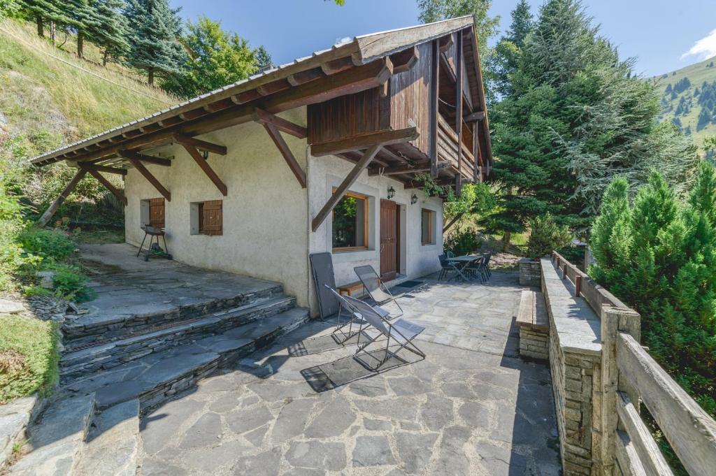 a house with a porch and a patio at Chalet La Darse Nature et Sérénité in Villard-Reculas
