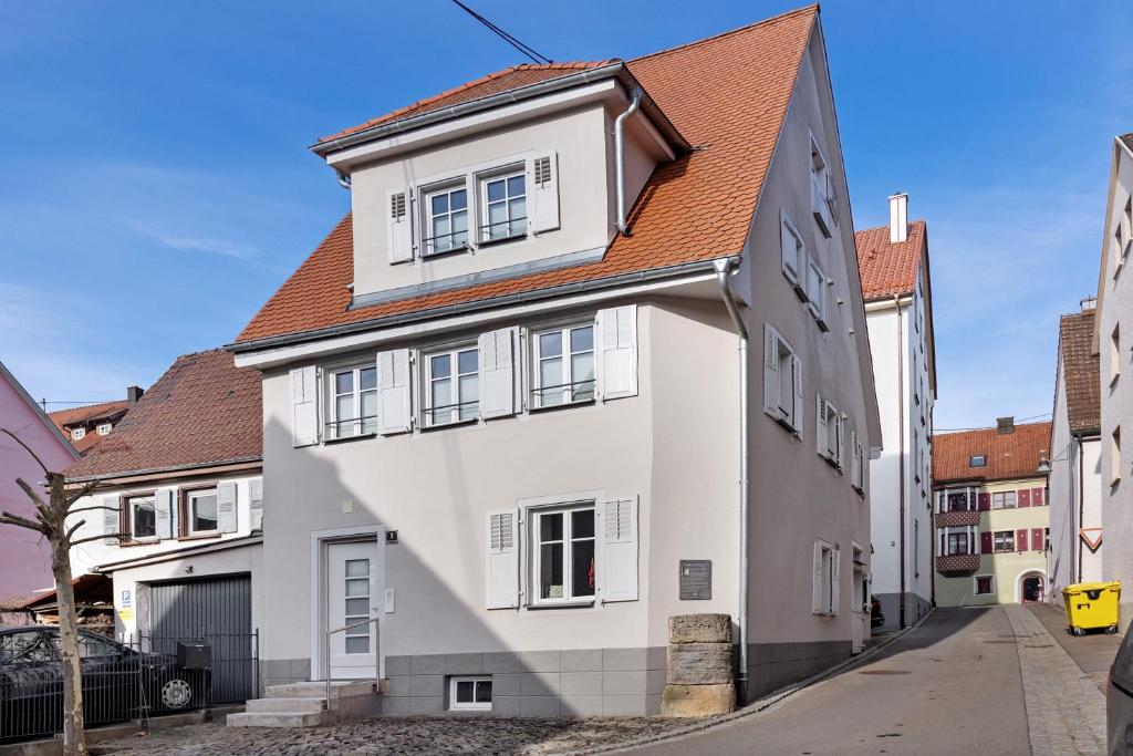a white house with a red roof on a street at Villa Arena in Geisingen