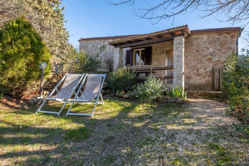 a chair in a yard in front of a house at Gufo in Pitigliano