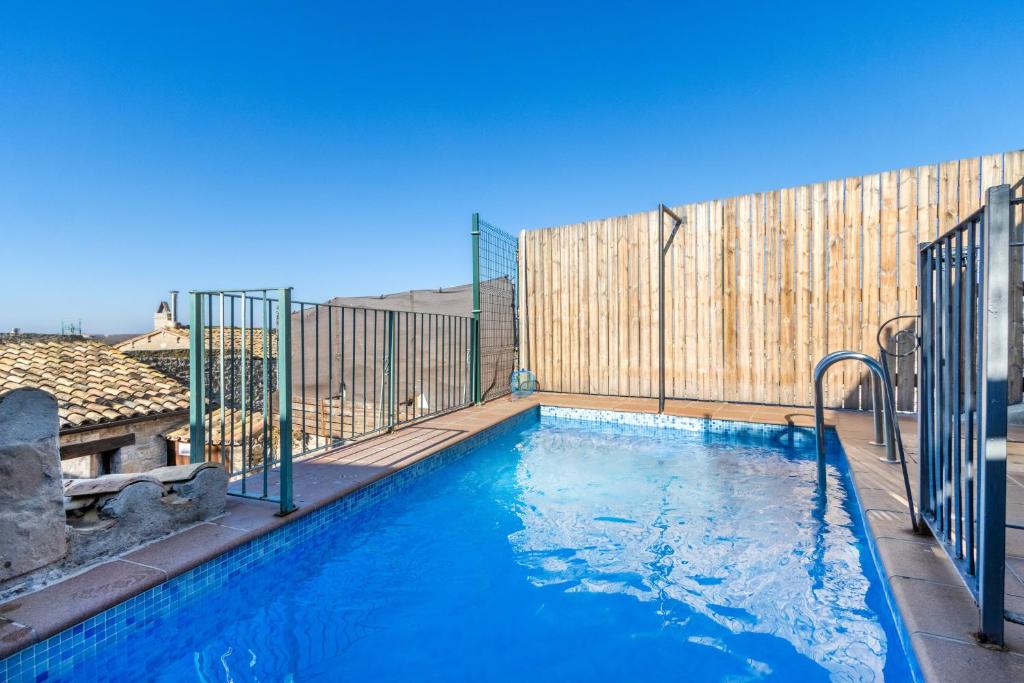 a swimming pool with a fence and blue water at Casabras Rural in Claravalls