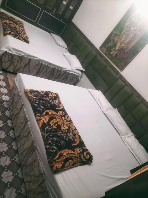 two beds in a room with a pillow on them at Shri Radha Raman Ji Seva Sadan in Mathura