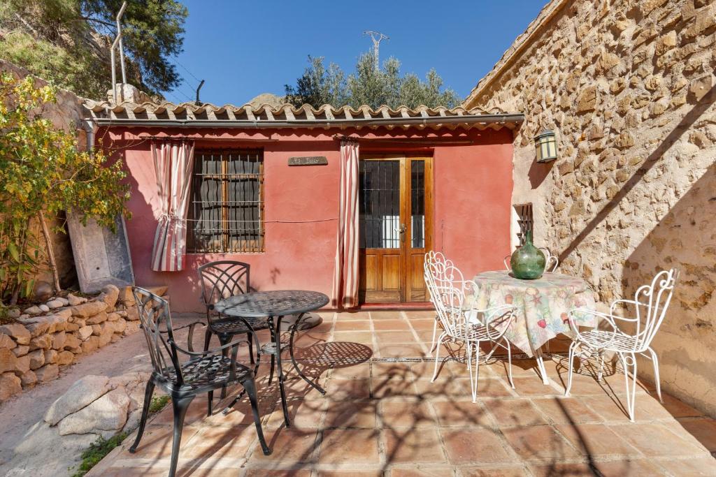 a patio with a table and chairs in front of a house at Casica de Perintín in Ojós