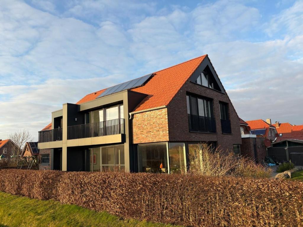 an image of a house with an orange roof at Großzügiges modernes Ferienhaus in Neuharlingersiel