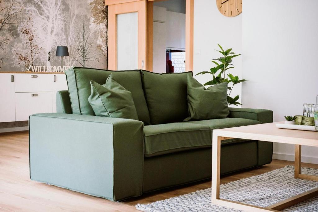 a green couch in a living room with a table at Fewo Waldfeeling in Brilon