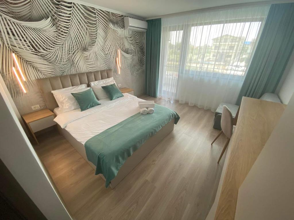 a bedroom with a bed and a large window at Casa Asteria - Mamaia Nord in Mamaia Sat/Năvodari