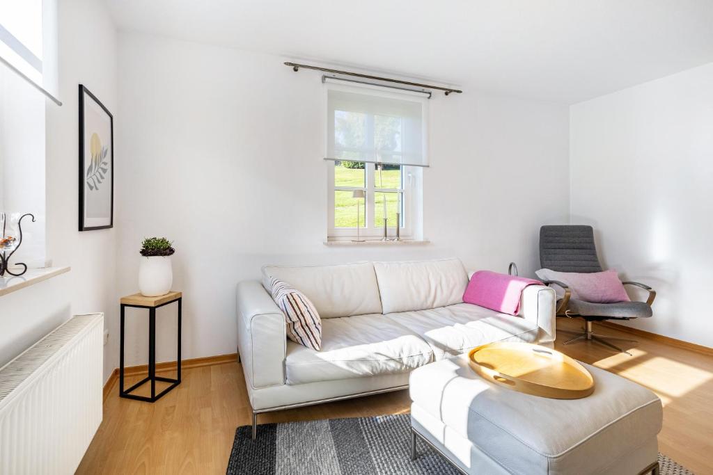 a living room with a white couch and a table at Fewo Allezeit Sauerland in Drolshagen