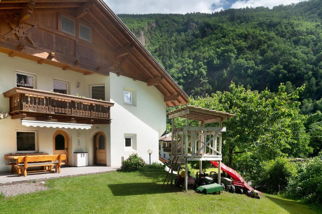 a house with a playground in the yard at Apartment Bodnerhof in Nova Ponente