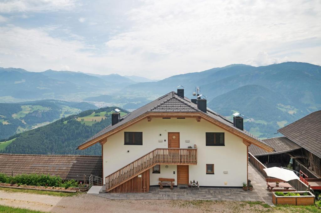 a house with a balcony and mountains in the background at Prielerhof in San Lorenzo di Sebato