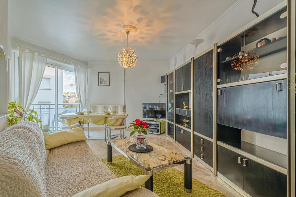 a living room with a couch and a table at Appartement Le Rial - Erquy in Erquy