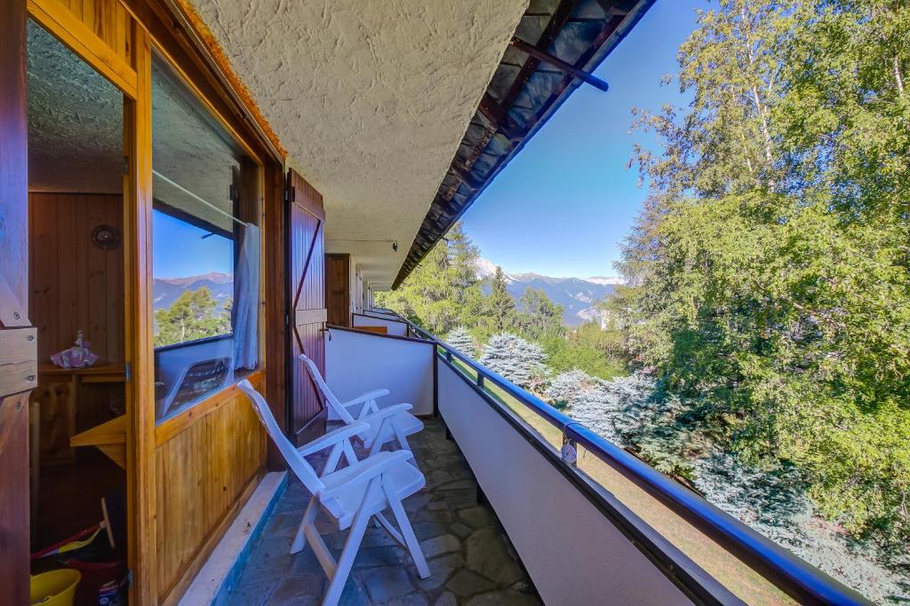 a room with two chairs on a balcony with a view at Appartamento Bareu Mountain View - Happy Rentals in Sauze dʼOulx