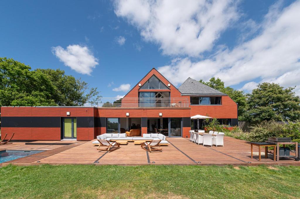 a house with a patio with a table and chairs at Chambre d'hôtes - Ty Castel in Ploeren